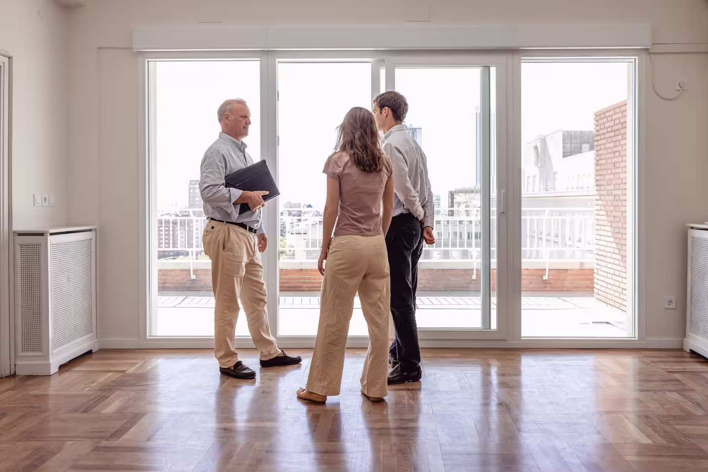 Immobilienmakler bei einer Wohnungsbesichtigung mit einem interessierten Paar